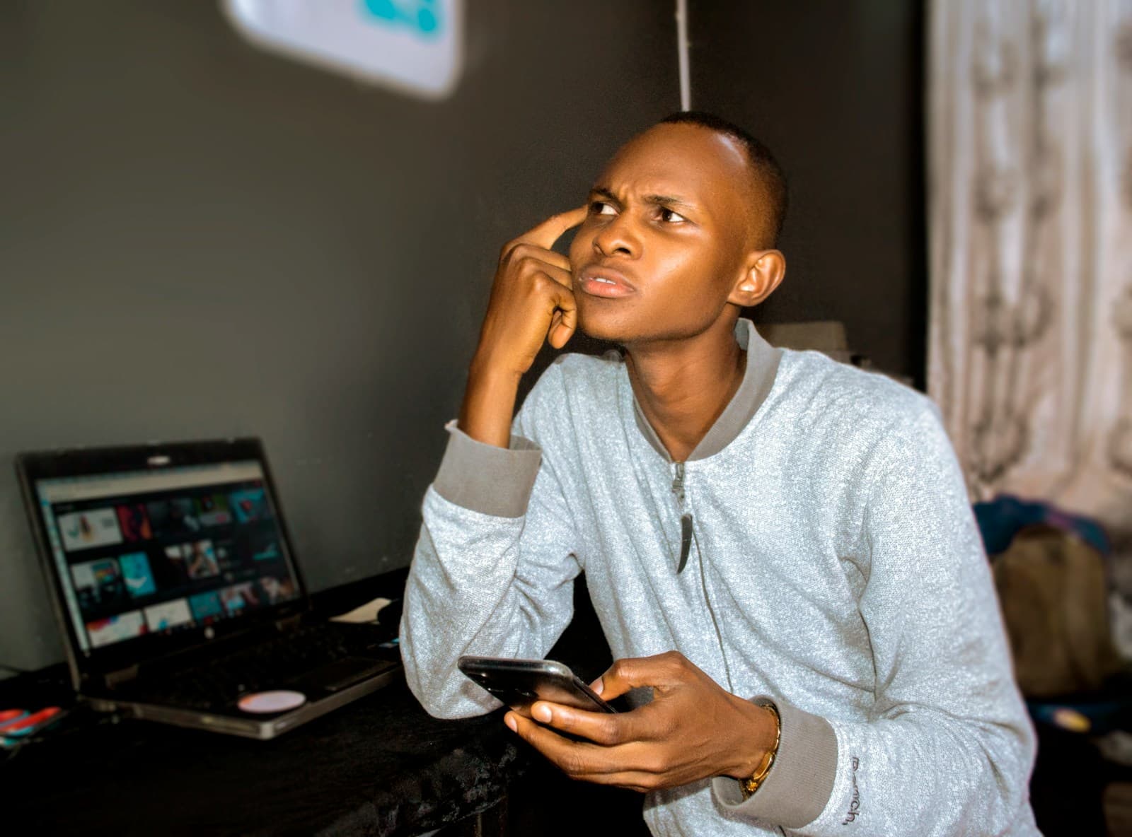 Jeune entrepreneur africain avec smartphone et ordinateur portable