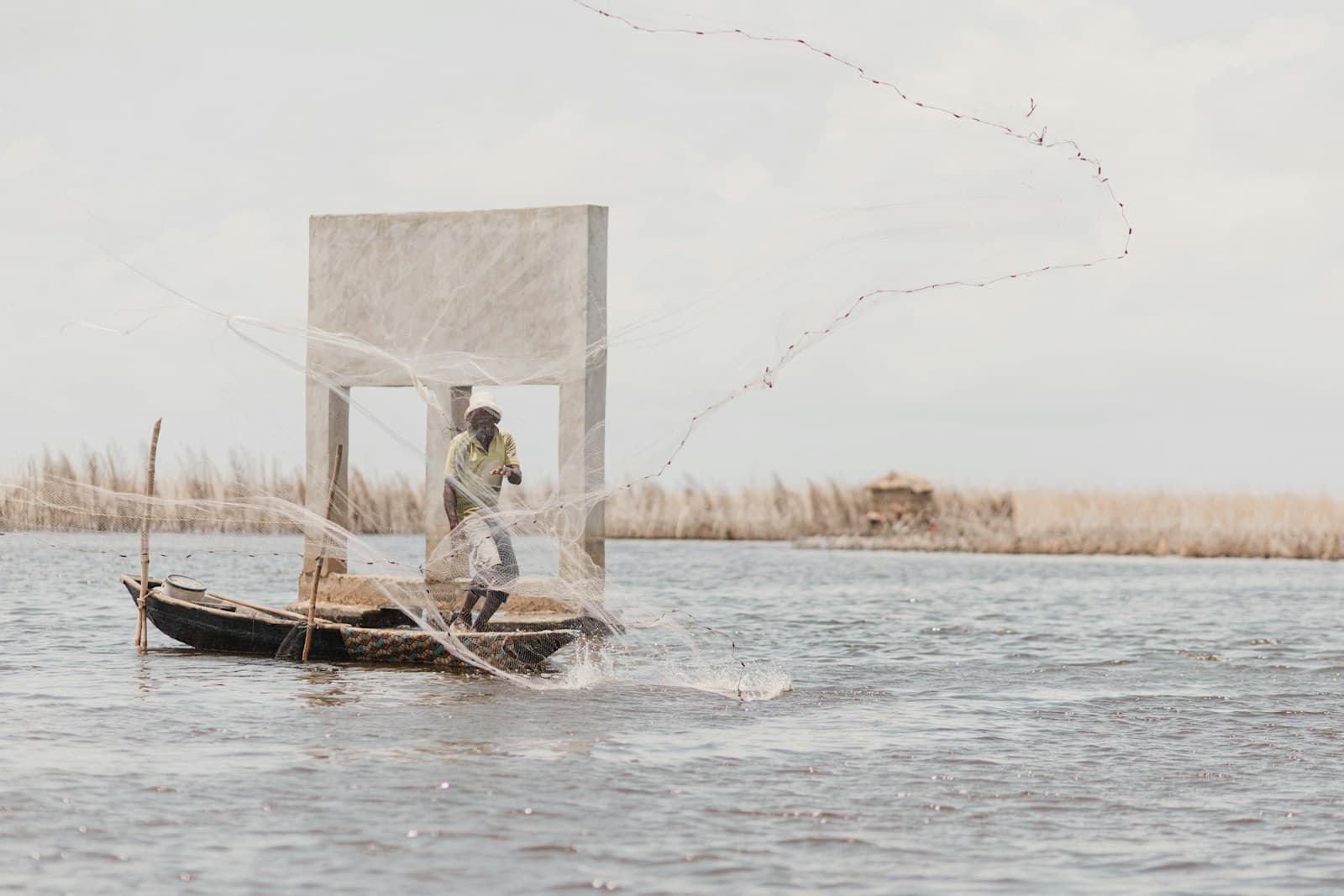 Pêcheur lançant son filet sur la lagune de Cotonou, Bénin